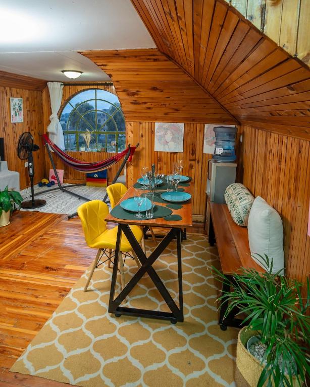 a living room with a table and a hammock at Kendi Stays - Rustic Penthouse Attic in Eldoret