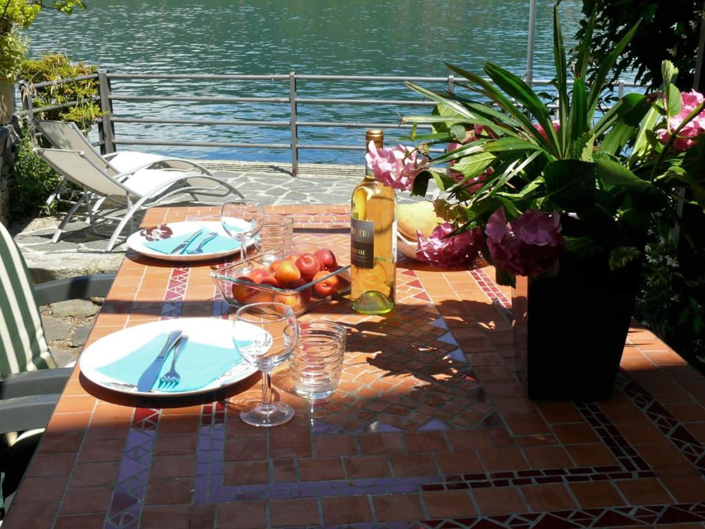 a table with plates of food and a bottle of wine at Casa Ronco al lago in Pella