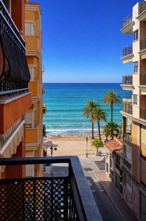 a view of the beach from the balcony of a building at Casa de Cludia in Santa Pola