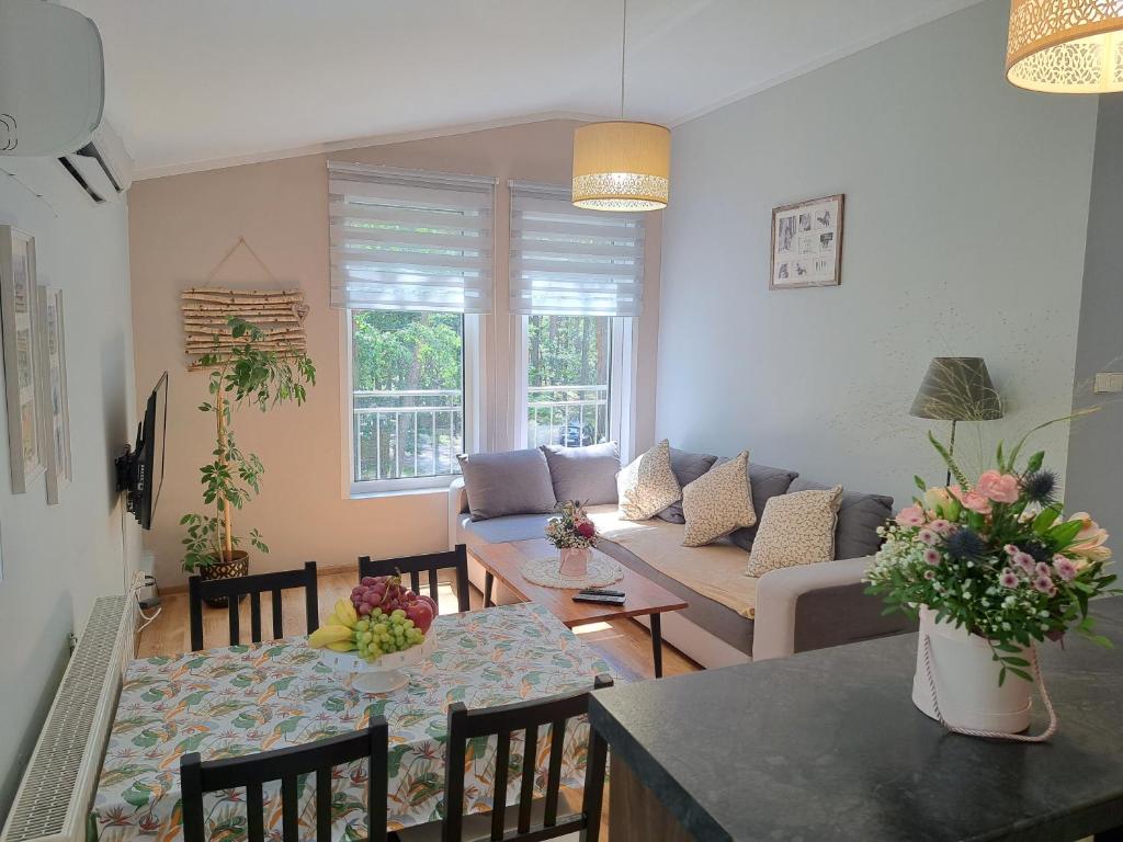 a living room with a couch and a table at Apartament nad Jeziorem Sławskim in Radzyń