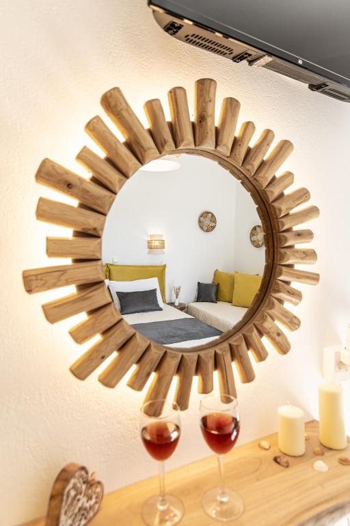 a mirror on a wall with two glasses of wine at Sunshine in Naxos Chora