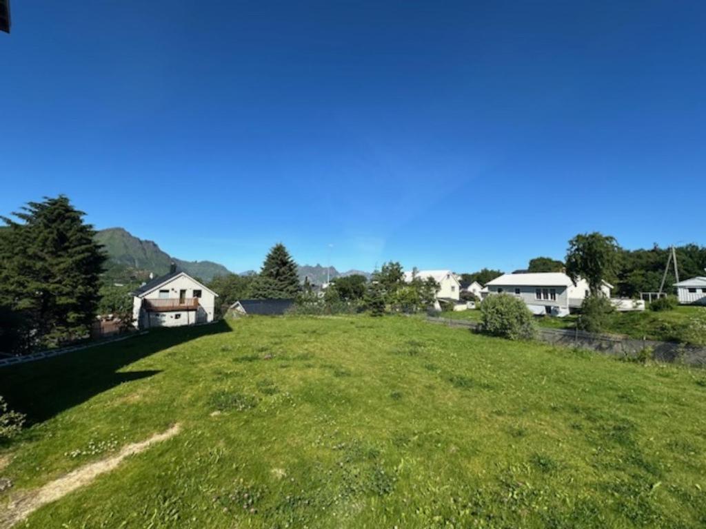a large green field with houses in the background at Åsen Apartment, Stamsund in Stamsund