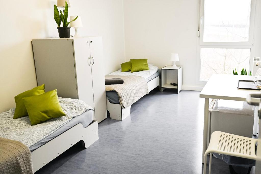 a room with two beds with green pillows at Hostel Września in Września