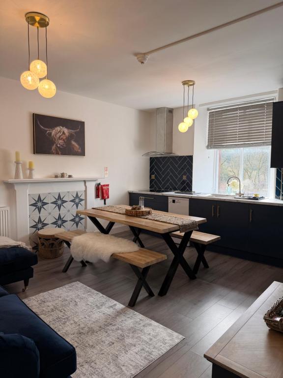 a living room with a table and a kitchen at The Old Bank in Moffat