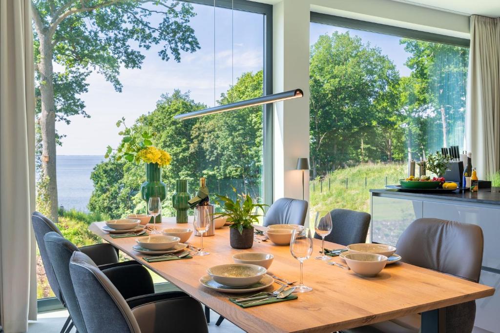 a dining room with a table and chairs and a large window at Apartment "Freya" - DECK9 Am Haff in Garz