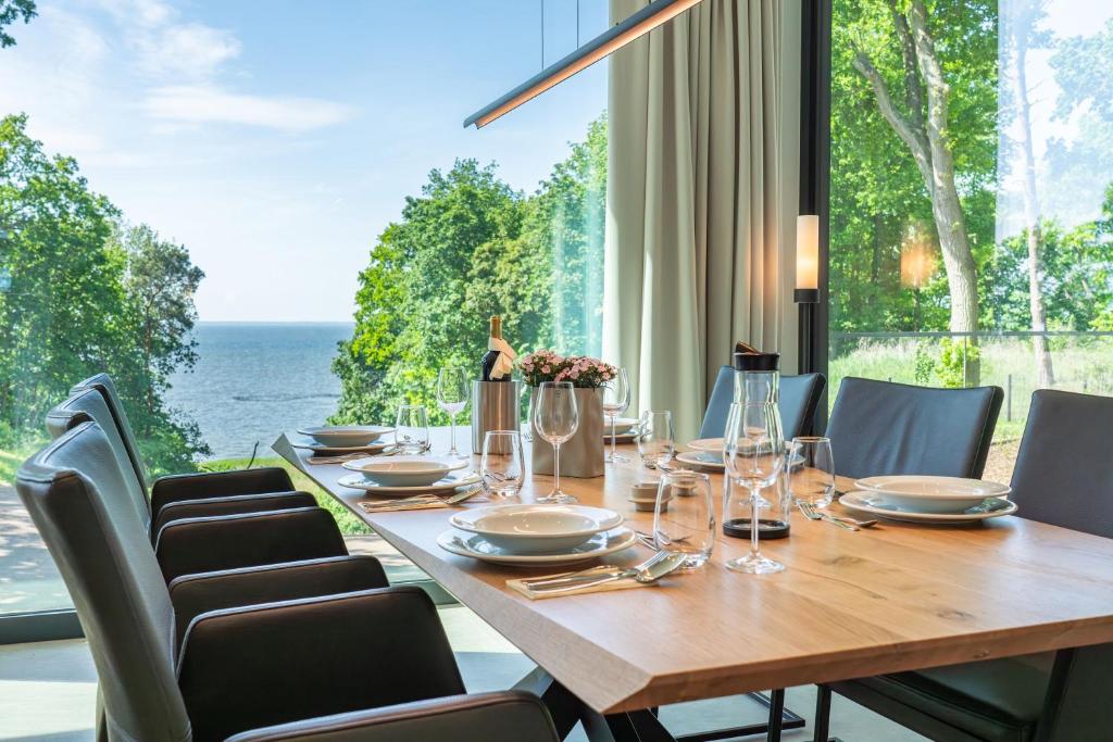 a dining room with a table and chairs with a view of the ocean at Apartment "Alva" - DECK9 Am Haff in Garz