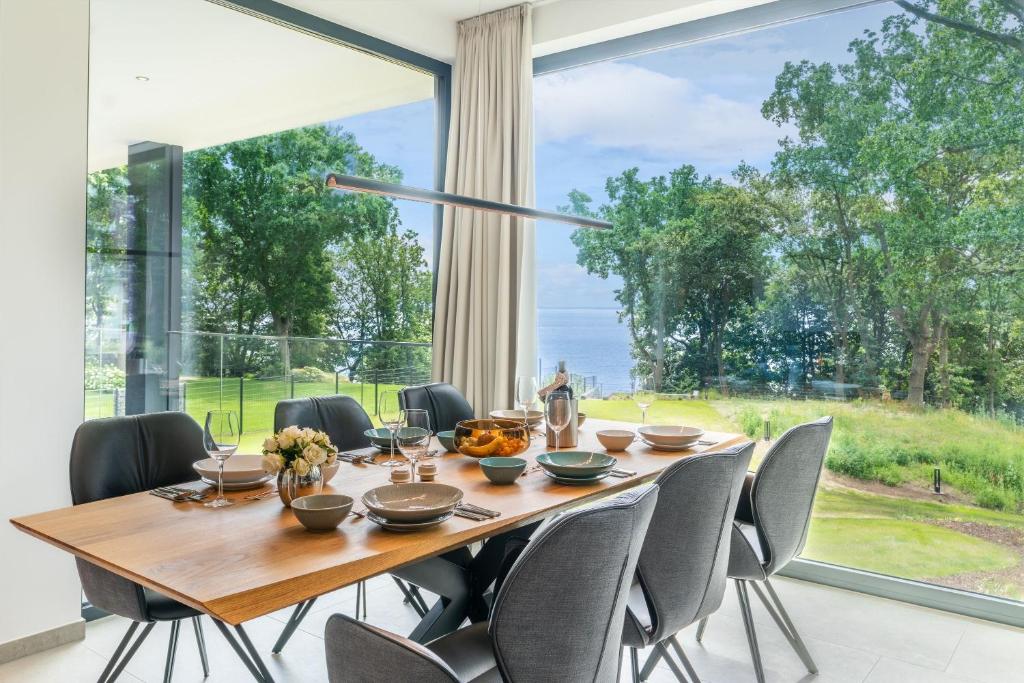 a dining room with a table and chairs and a large window at Apartment "Smilla" - DECK9 Am Haff in Garz