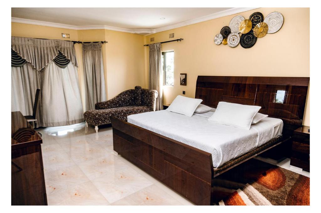 a bedroom with a bed and a chair and plates on the wall at Leon's Hotel in Choma