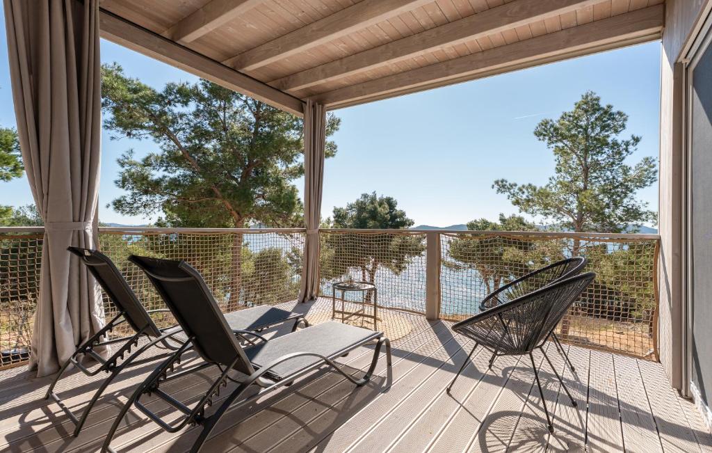 a screened porch with chairs on a deck at Mobile home Azzurro in Drage
