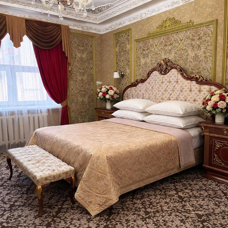 ein Schlafzimmer mit einem Kingsize-Bett mit Baldachin in der Unterkunft Lion Hotel in Astana