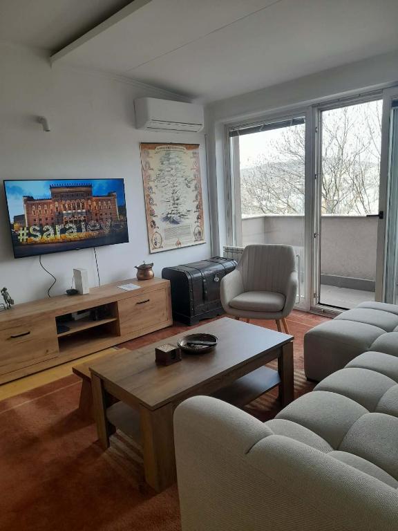 a living room with couches and a tv and a table at Villa Sabic - Free Garage & Panoramic View in Sarajevo