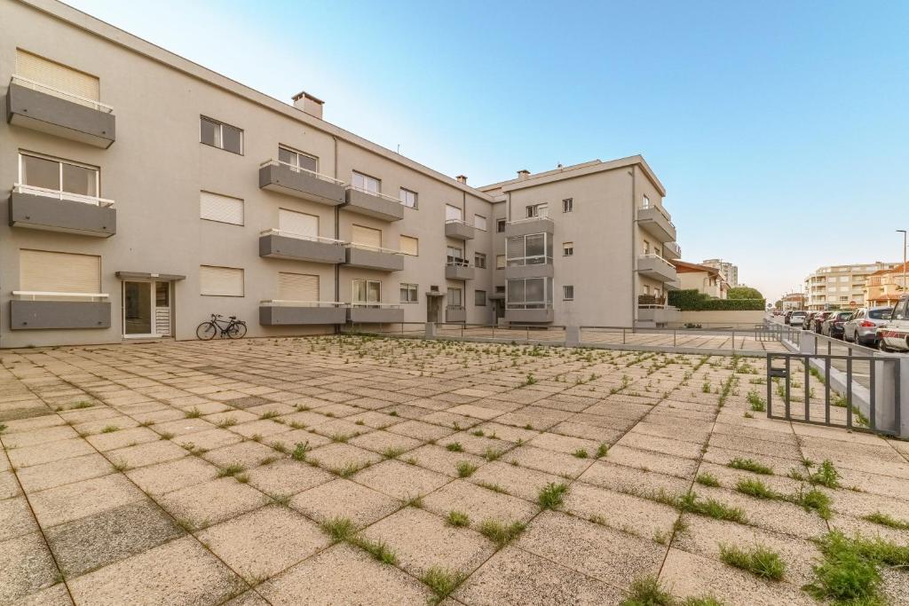 an empty parking lot in front of a building at Excellent location, good access to the beach in Vila do Conde