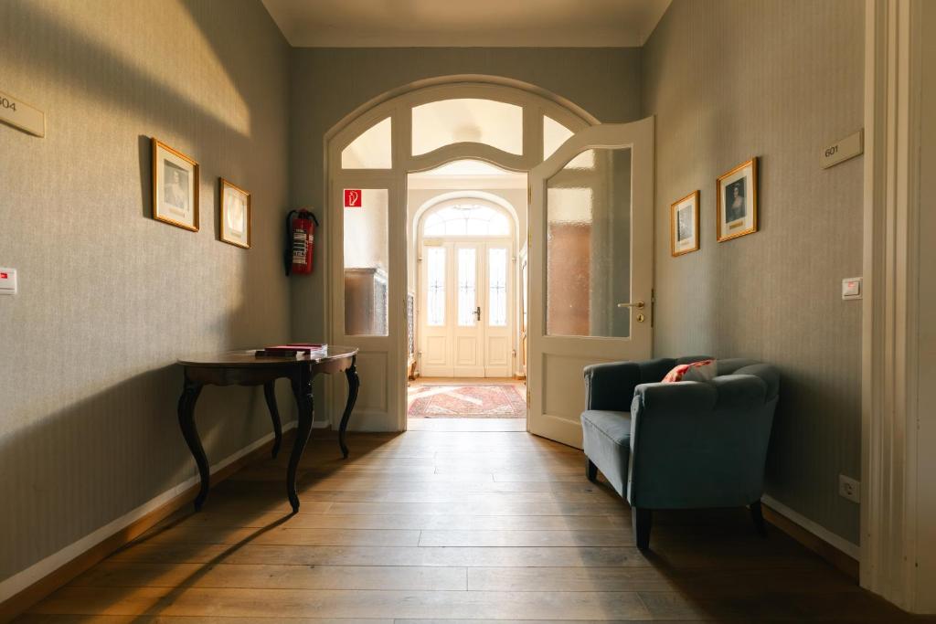 a hallway with a door and a chair and a table at Villa Widder - Boutiquehotel in Staatsbad Brückenau