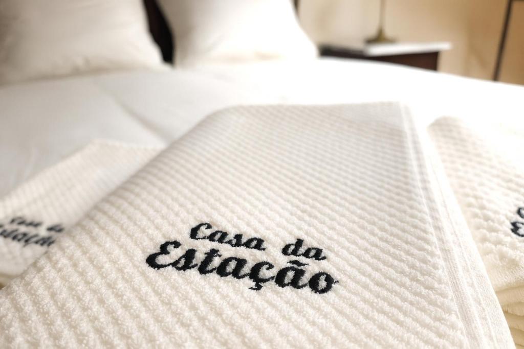 a towel on a bed with the words casa historica on it at Casa da Estação in Torre de Moncorvo