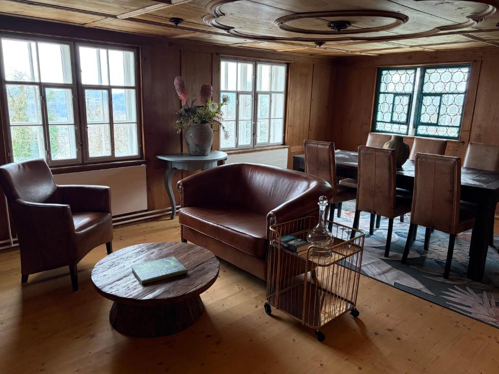 a living room with a couch and a table and chairs at Ferienwohnung Obstgarten in Märstetten