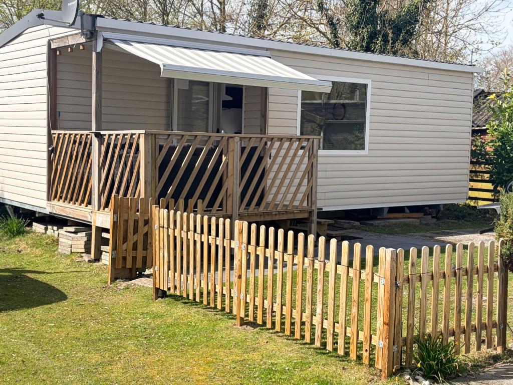 a wooden fence in front of a tiny house at Strand chalet Makkum in Makkum