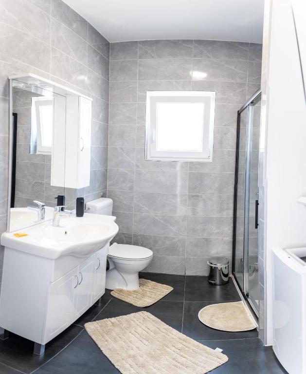 a bathroom with a white sink and a toilet at Apartmani Ljubica in Selce