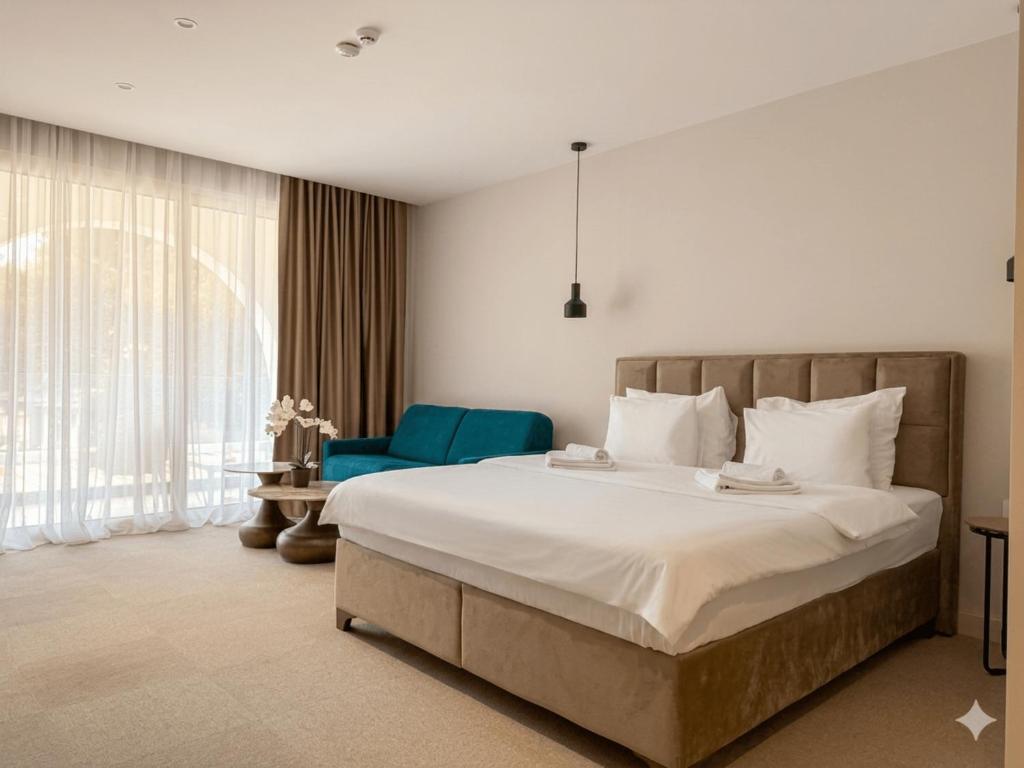 a bedroom with a large bed and a blue chair at Hotel Riva in Budva