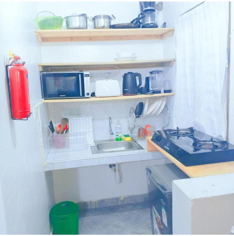 a kitchen with a sink and a microwave at kandys place in Watamu