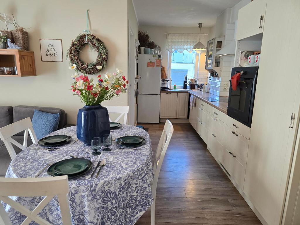 a kitchen with a table with a vase of flowers on it at Family Home FeWo de lux Świnoujście in Świnoujście