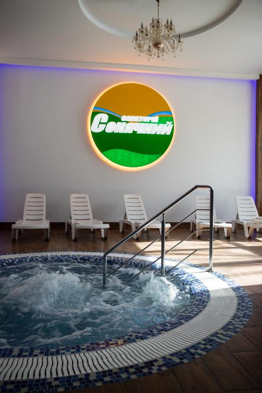 a hot tub in a room with chairs and a sign at Санаторій Сонячний in Verbki
