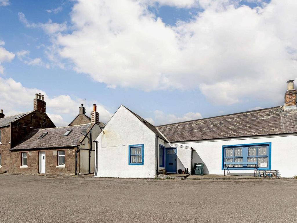 a white building next to a brick building at 2 Bed in Montrose oc-an48m in Johnshaven