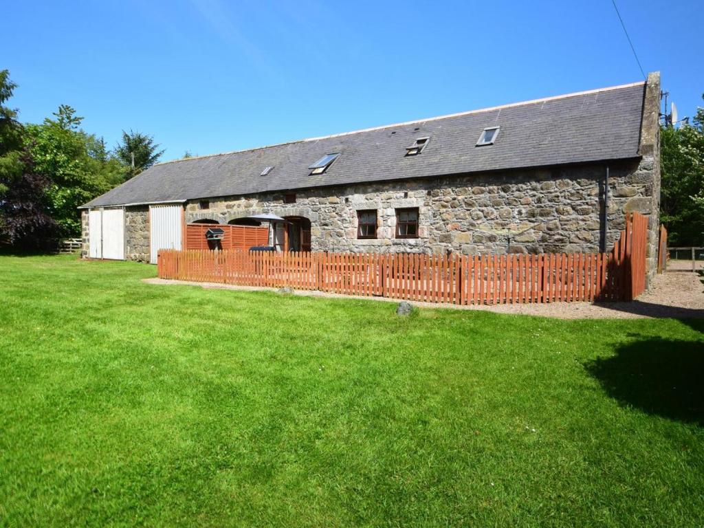 an old stone barn with a fence in a yard at 3 Bed in Huntly oc-57368 in Insch