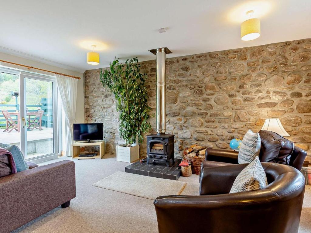 a living room with a stone wall at 1 Bed in Beauly oc-82779 in Beauly