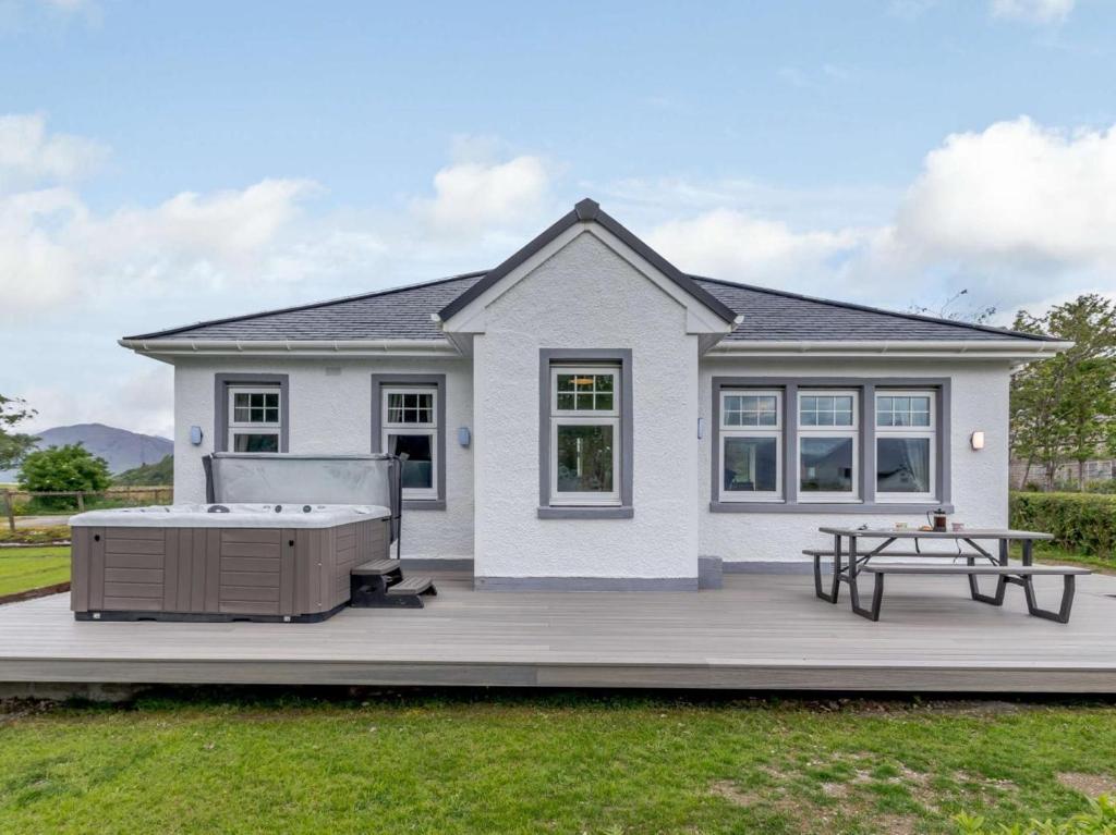 a house with a hot tub and a picnic table at 2 Bed in Fort William oc-83310 in Onich