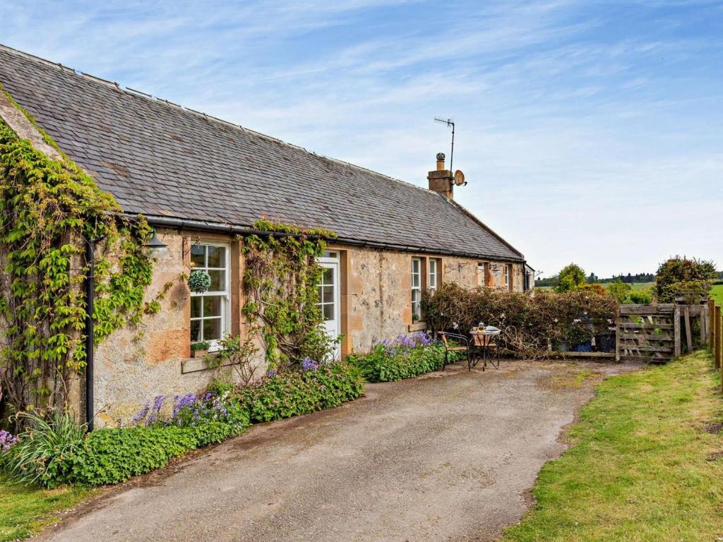 an old stone house with ivy growing on it at 2 Bed in Dingwall oc-ca387 in Cononbridge