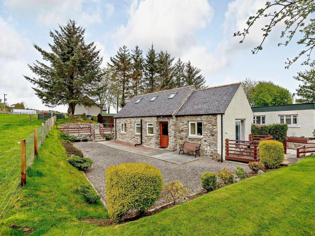 a stone cottage with a red door in a yard at 1 Bed in Beauly oc-82778 in Beauly