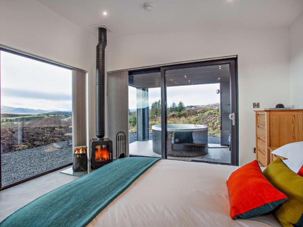 a bedroom with a bed with a fireplace and a tub at 1 Bed in Ardgay oc-90470 in Bonar Bridge
