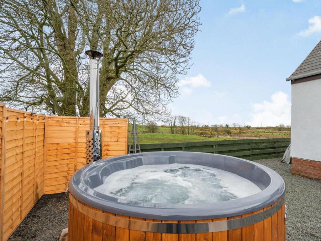 a jacuzzi tub in a yard next to a fence at 3 Bed in Newton Stewart oc-87541 in Mochrum