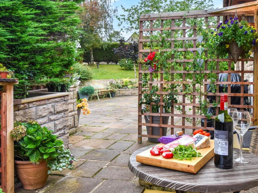 a garden with a table with vegetables and wine bottles at 1 Bed in Dollar oc-95872 in Powmill