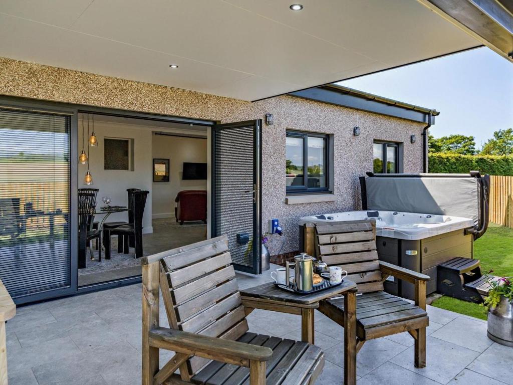a patio with two chairs and a hot tub at 3 Bed in Anstruther oc-96111 in Pittenweem