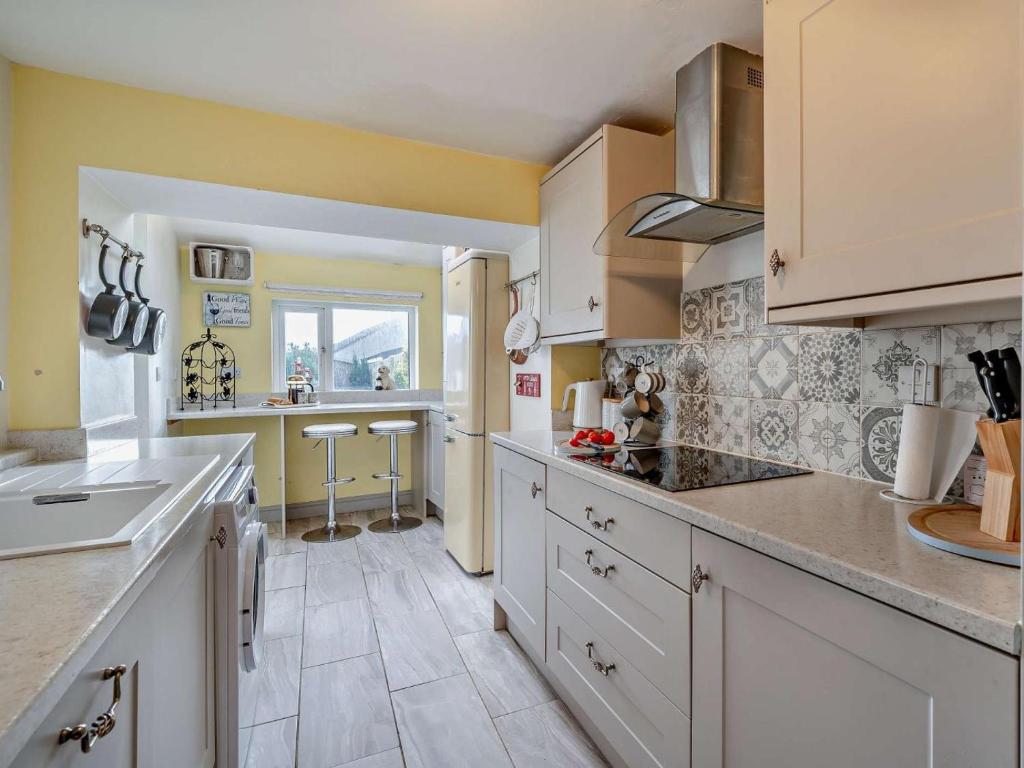 a kitchen with white cabinets and a counter top at 2 Bed in Millom oc-93608 in Millom