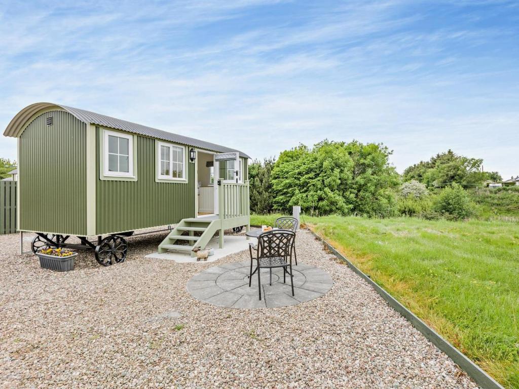 a green tiny house with a table and chairs at 1 Bed in Forfar oc-92331 in Kingsmuir