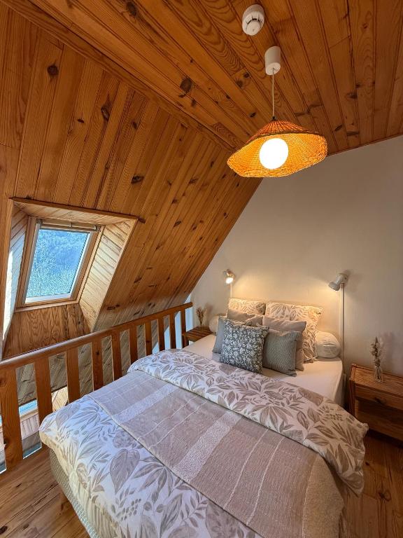 a bedroom with a large bed in a wooden ceiling at Le Domaine Belinay in Paulhac