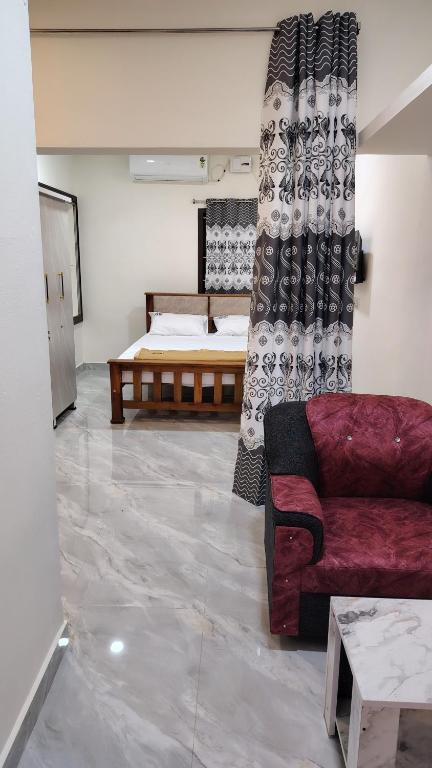 a living room with a couch and a bed at Golden Stay Inn in Kovakulam