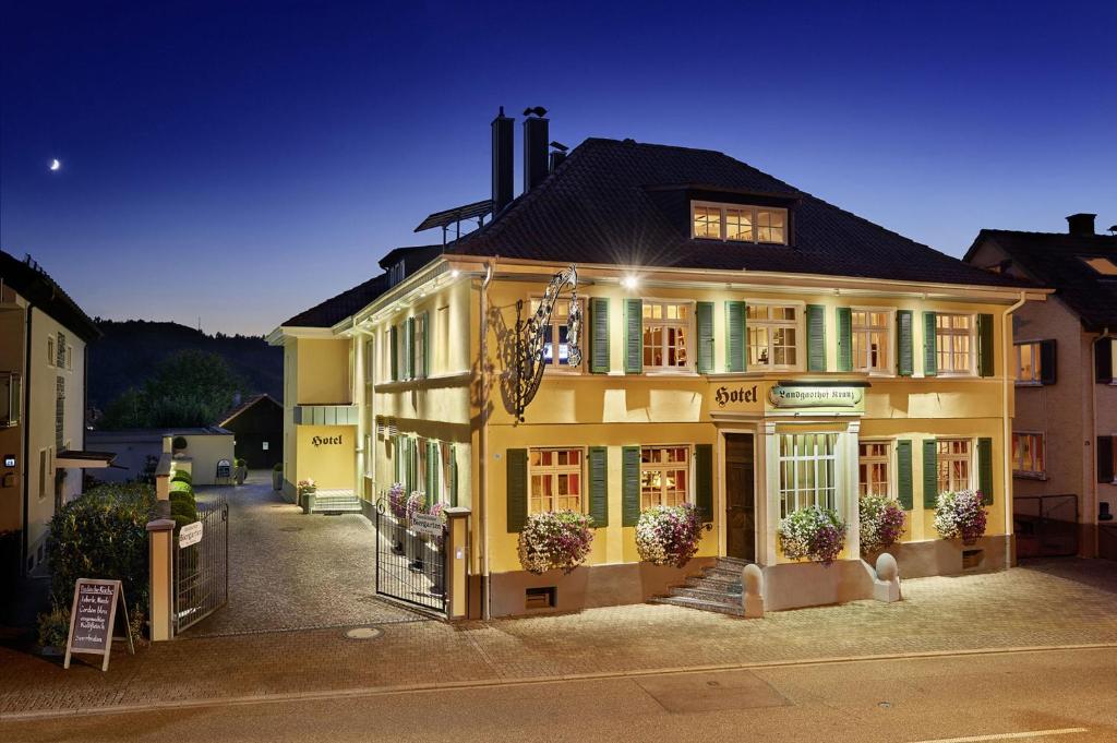 a large yellow building with flowers in front of it at Landgasthof Kranz in Ohlsbach