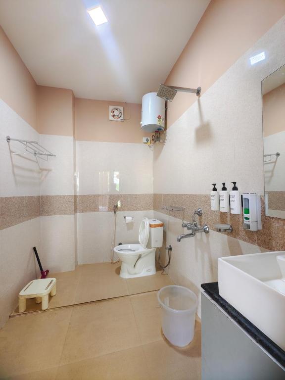 a bathroom with a toilet and a sink at Tusker Tea County in Mal bazar