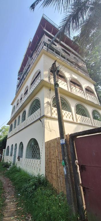 a large white building with a fence in front of it at Saraswati Kunj in mayapur
