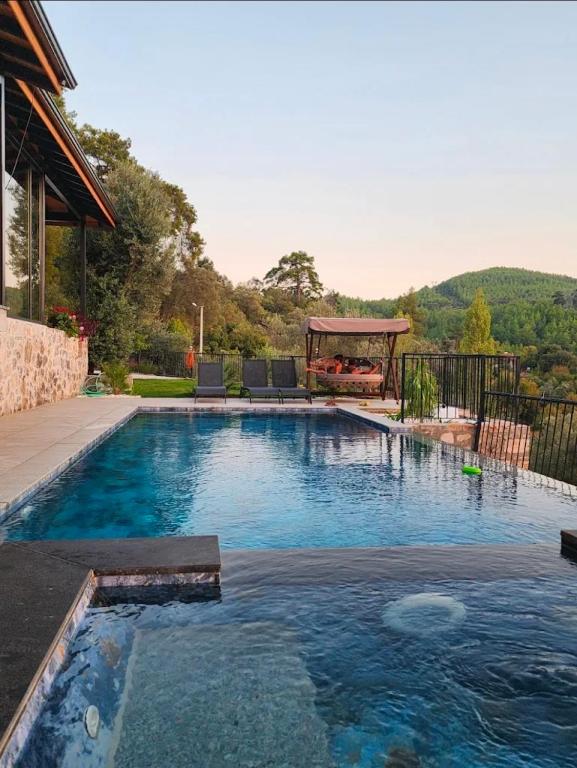 a swimming pool with a gazebo in a backyard at Villa Skylight Göcek Fethiye in Fethiye