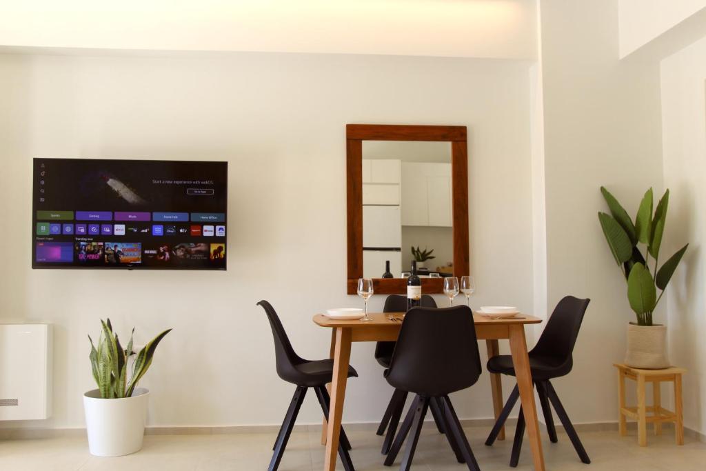 a dining room with a table and chairs and a mirror at SUMU Luxury Apartment in Lefkada