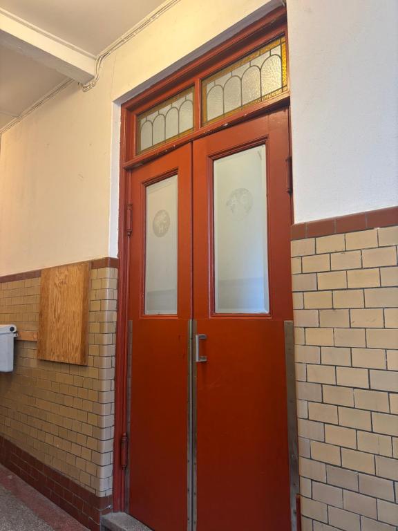 a red door in a brick building with windows at Charmigt boende på i centrala Helsingborg in Helsingborg