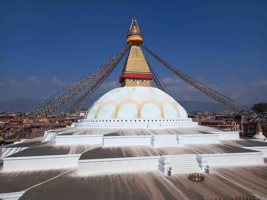 a large white building with a gold steeple on top at Serenity stay in Kathmandu