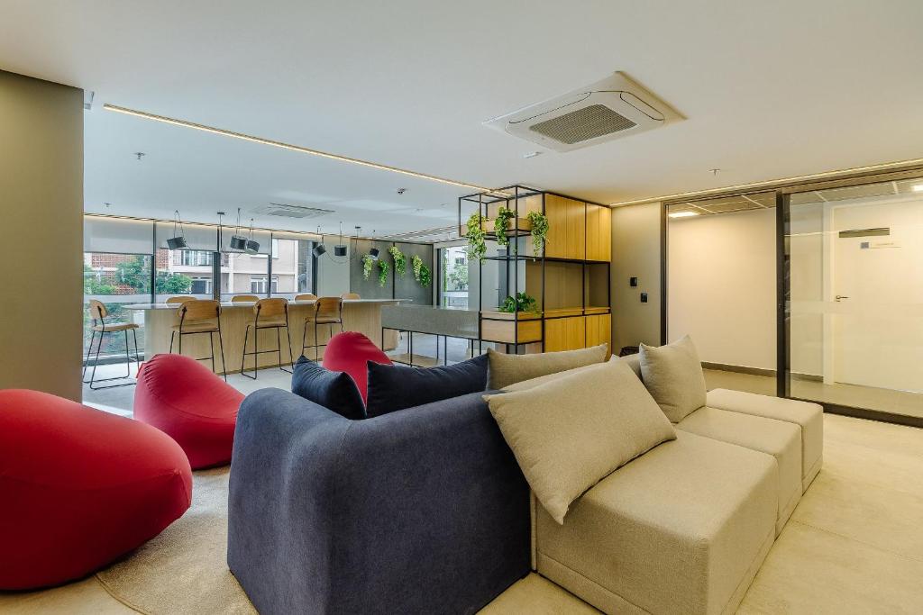 a living room with a couch and red chairs at Soul República - Cidade Baixa in Porto Alegre