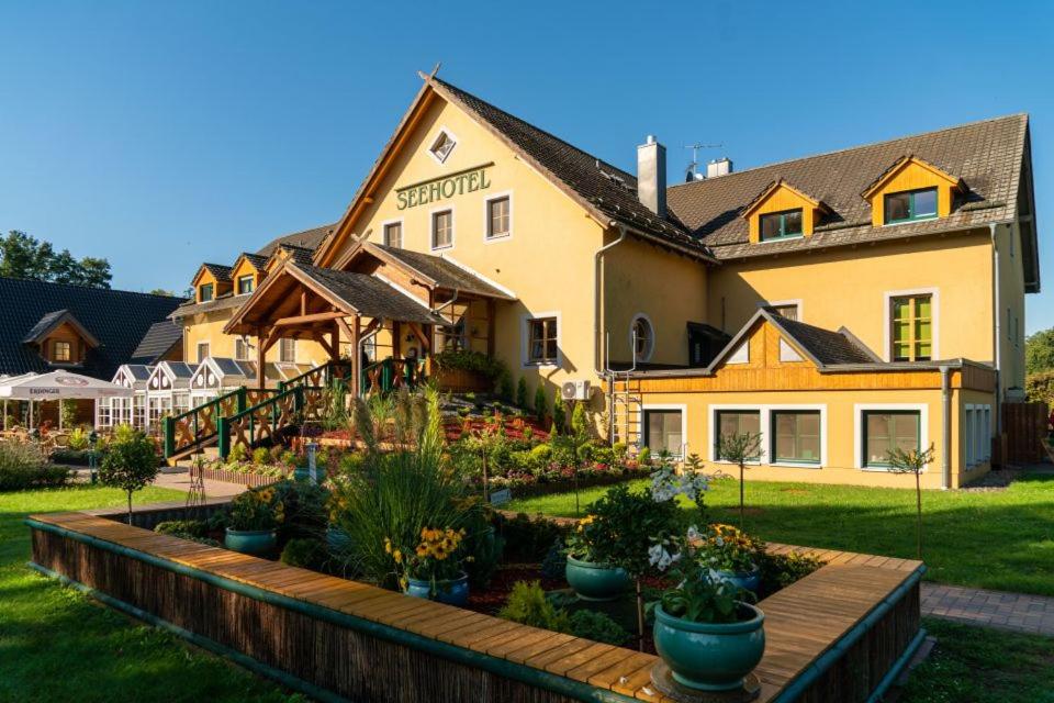 a hotel with a garden in front of a building at Seehotel Burg Spreewald in Byhleguhrer Kaupen