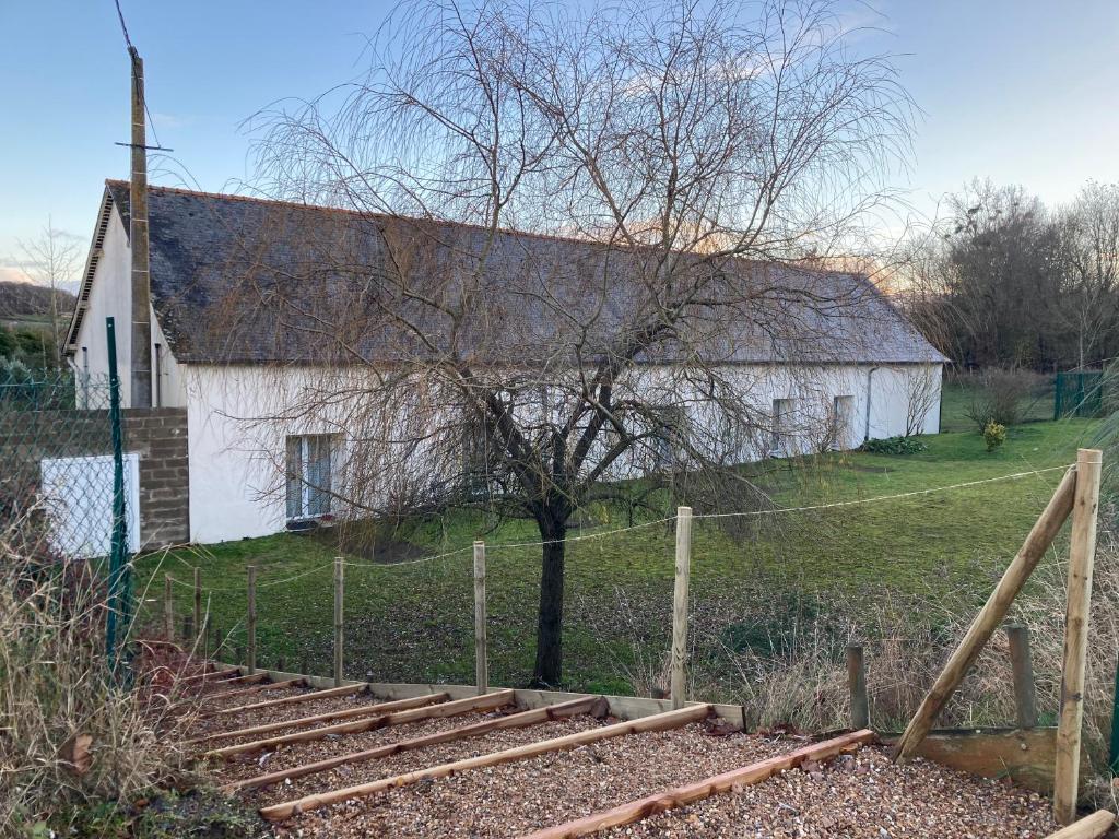 an old white building with a tree and train tracks at Chambres à 2 pas du Mans in Trangé
