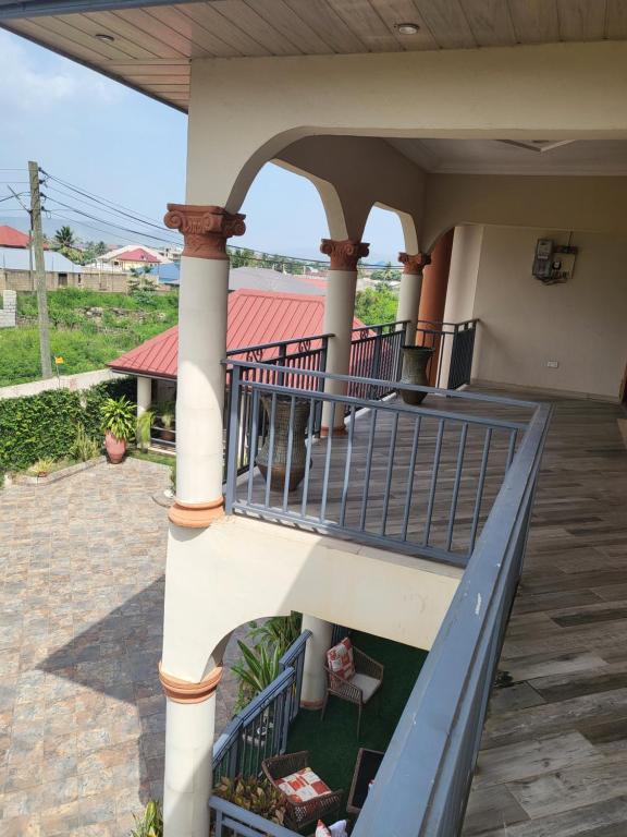 a porch of a house with a blue railing at Steco rental in Amasaman